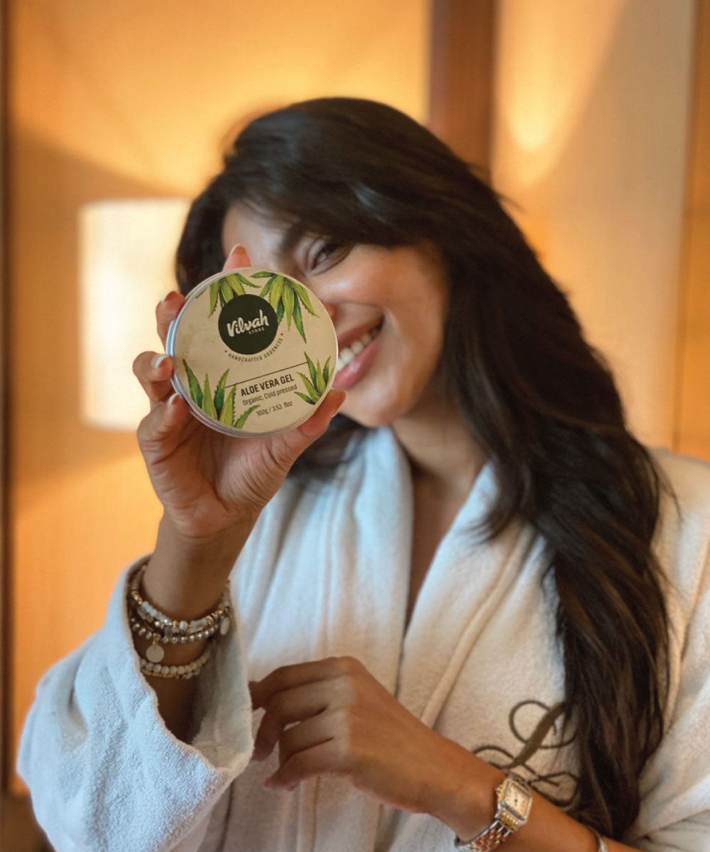 a woman showing Vilvah aloe vera gel to apply on her face at night